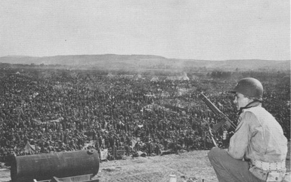 Żołnierz amerykański pilnuje niemieckich jeńców w 1945 r.