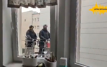 Policjanci na wysięgniku przed oknem mieszkania wynajętego przez Lotną Brygadę Opozycji