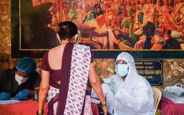 Lekarz w Bombaju szykuje się do pobrania próbek do testów