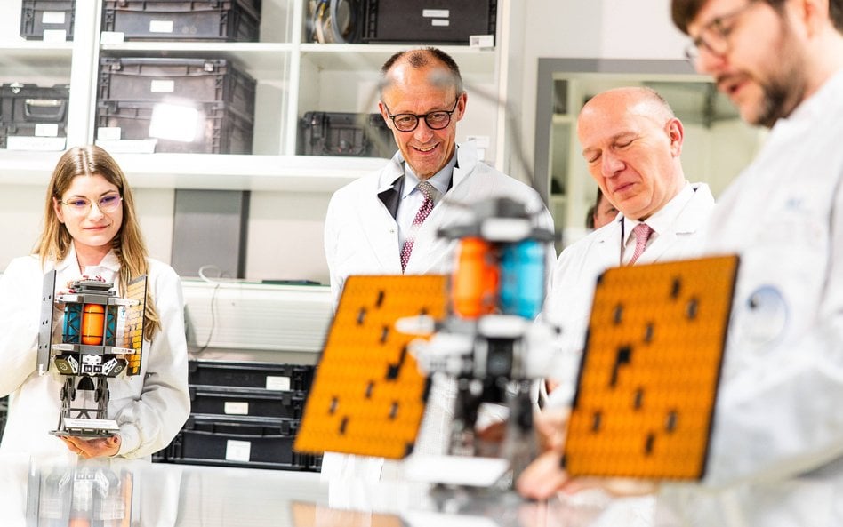 Kanclerz Niemiec Friedrich Merz ogląda satelitę podczas wizyty w firmie Berlin Space Technologies (B