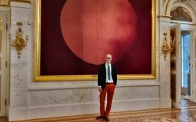 Nicolas Grospierre na tle czerwonej holografii w Sali Salomona