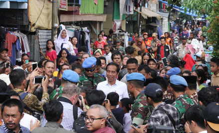 Joko Widodo na zdjęciu w środku, otoczony przez żołnierzy