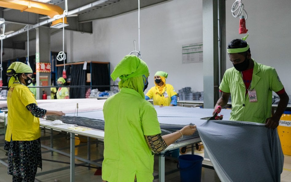 Pracownik tnie kawałek materiału w fabryce odzieży Urmi Group w Narayanganj w Bangladeszu