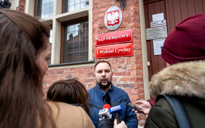 Poszkodowany Mariusz Milewski (C) przed budynkiem Sądu Okręgowego w Toruniu