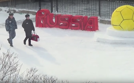 Brama wejściowa do łagru. Więzień odprowadzany przez strażnika