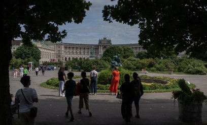 Ludzie spacerują po Volksgarten między Burg Theater a pałacem Hofburg w Wiedniu
