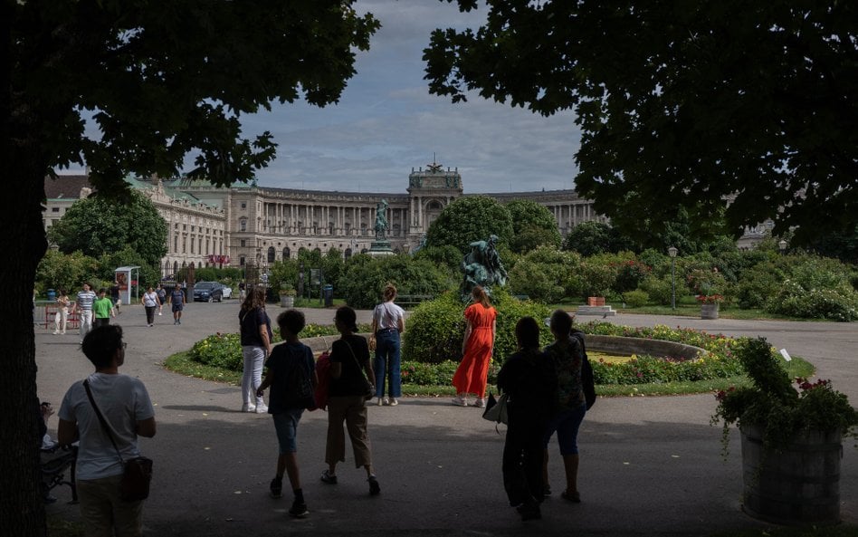 Ludzie spacerują po Volksgarten między Burg Theater a pałacem Hofburg w Wiedniu
