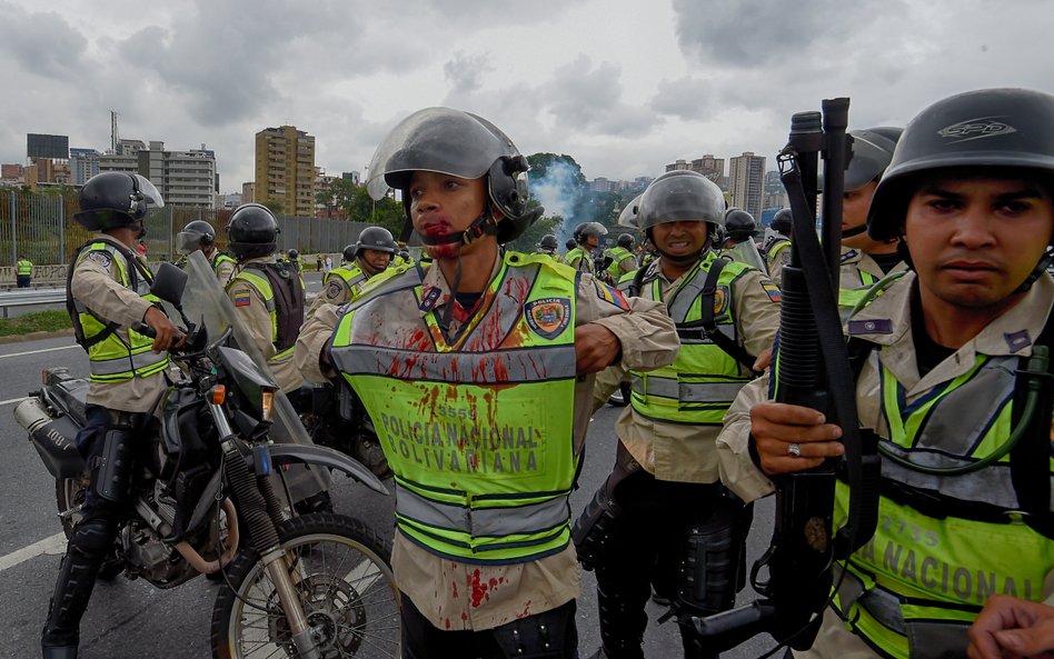 Policjanci po starciach z demonstrantami na ulicach Caracas 11 maja