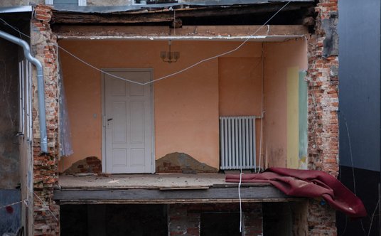 Widok z ulicy Łąkowej na zniszczony budynek nad rzeką Białą Lądecką w Lądku Zdroju