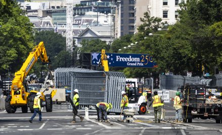 Ekipy budowlane budują ogrodzenie wzdłuż Pennsylvania Avenue przed wyścigiem Freedom 250 Grand Prix 