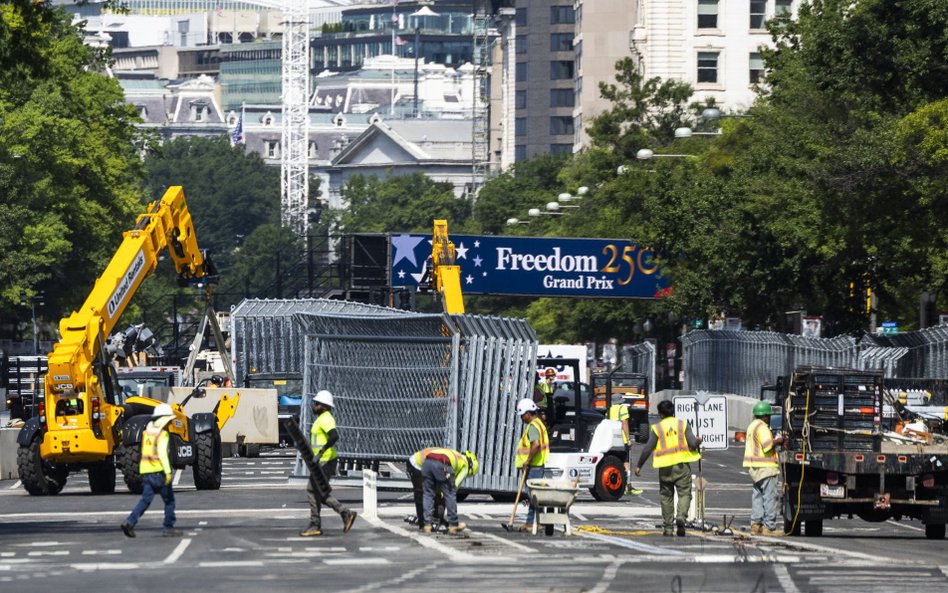 Ekipy budowlane budują ogrodzenie wzdłuż Pennsylvania Avenue przed wyścigiem Freedom 250 Grand Prix 