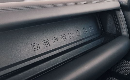 Defender ma w środku wiele ciekawych detali - na zdjęciu napis na desce rozdzielczej przed pasażerem