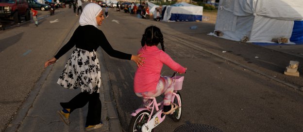 Ulice Bejrutu, dzieci bawią się przy namiotach uchodźców z południa kraju