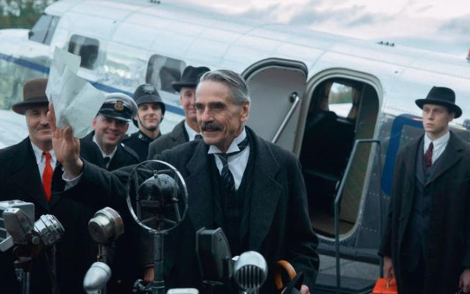 Jeremy Irons jako Neville Chamberlain. Po prawej Georges MacKay jako Hugh Legat