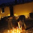 Cyganie palą świece koło domu, który spłonął od ataku koktajlami Mołotowa. Nieznani sprawcy zastrzel