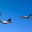 Szwedzkie samoloty wielozadaniowe Saab JAS-39C Gripen w locie w szyku z amerykańskimi F-16C podczas 