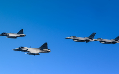 Szwedzkie samoloty wielozadaniowe Saab JAS-39C Gripen w locie w szyku z amerykańskimi F-16C podczas 