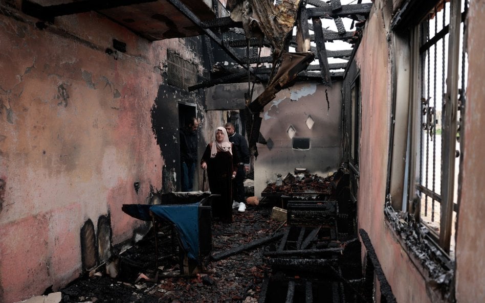 Palestyńczycy oglądają zniszczony dom, spalony - jak twierdzą – przez izraelskich osadników w Al-Fan