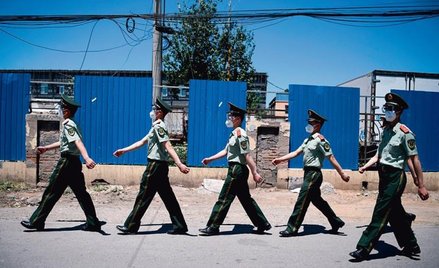 Chińscy policjanci zamykają jeden z targów z owocami morza w Pekinie