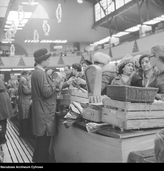 Stoisko z owocami i warzywami w Hali Mirowskiej. Ekspedientki obsługują stojących w kolejce klientów