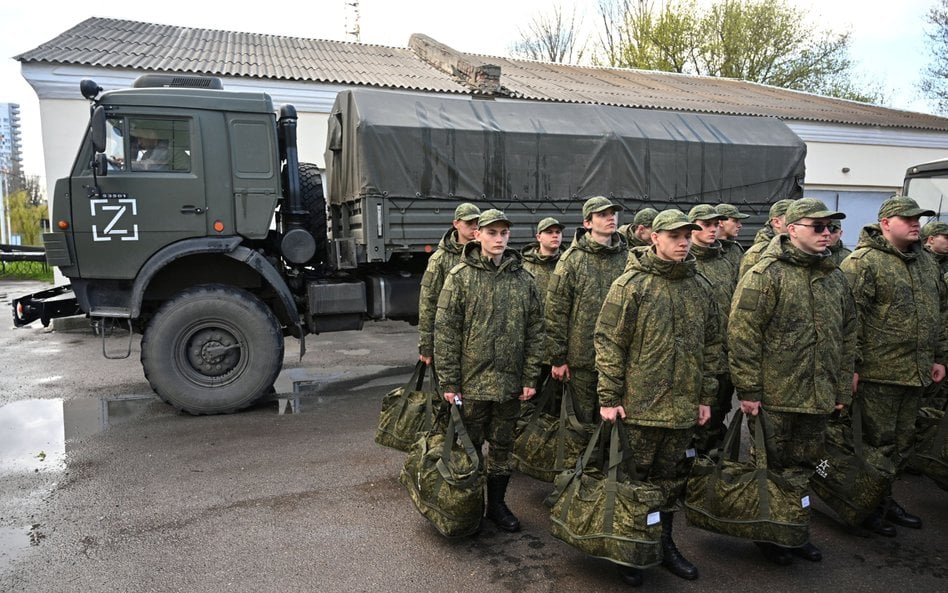Rosja. Poborowi wezwani do odbycia służby wojskowej ustawiają się w szeregu przed wyjazdem do koszar