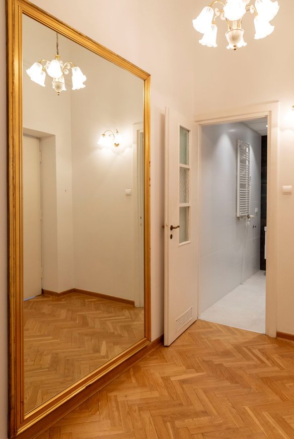 Ogromne lustro w hallu potęguje wrażenie przestrzeni. Podkreśla także wyjątkową wysokość lokalu.