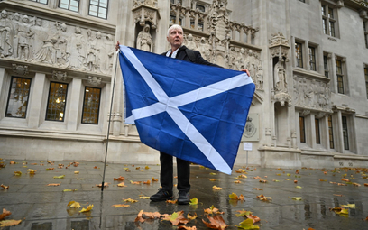 Zwolennik niepodległości Szkocji pozuje z flagą przed budynkiem Sądu Najwyższego Zjednoczonego Króle