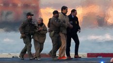 Funkcjonariusze wyprowadzają z helikoptera pojmanego prezydenta Wenezueli Nicolás Maduro i jego żonę