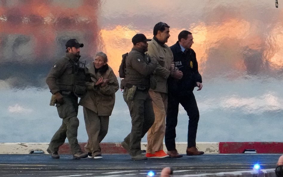 Funkcjonariusze wyprowadzają z helikoptera pojmanego prezydenta Wenezueli Nicolás Maduro i jego żonę