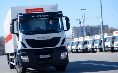 Ciężarówka Poczty Polskiej na parkingu przed zaparkowanymi furgonami