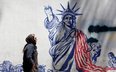 Iranka obok antyamerykańskiego muralu w pobliżu dawnej ambasady USA w Teheranie.