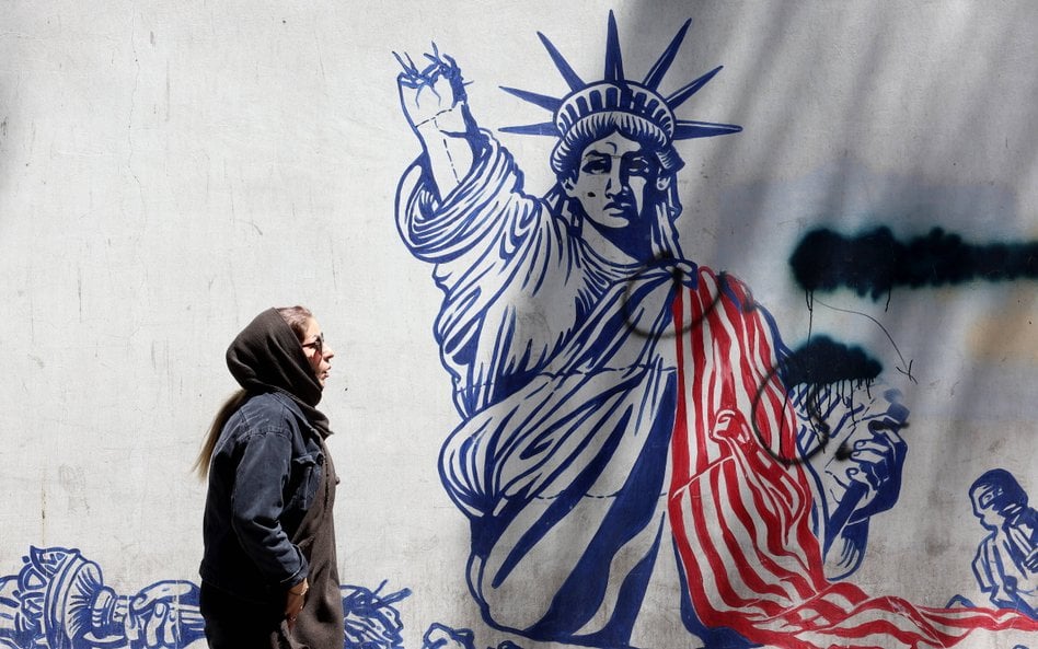 Iranka obok antyamerykańskiego muralu w pobliżu dawnej ambasady USA w Teheranie.