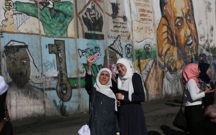 Palestyńskie kobiety robiące „selfie” w pobliżu punktu kontrolnego między Ramallah i Jerozolimą. Wie