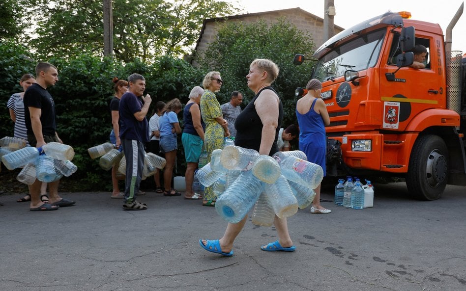 Mieszkańcy Doniecka czekają w kolejce, aby odebrać wodę dostarczoną cysterną