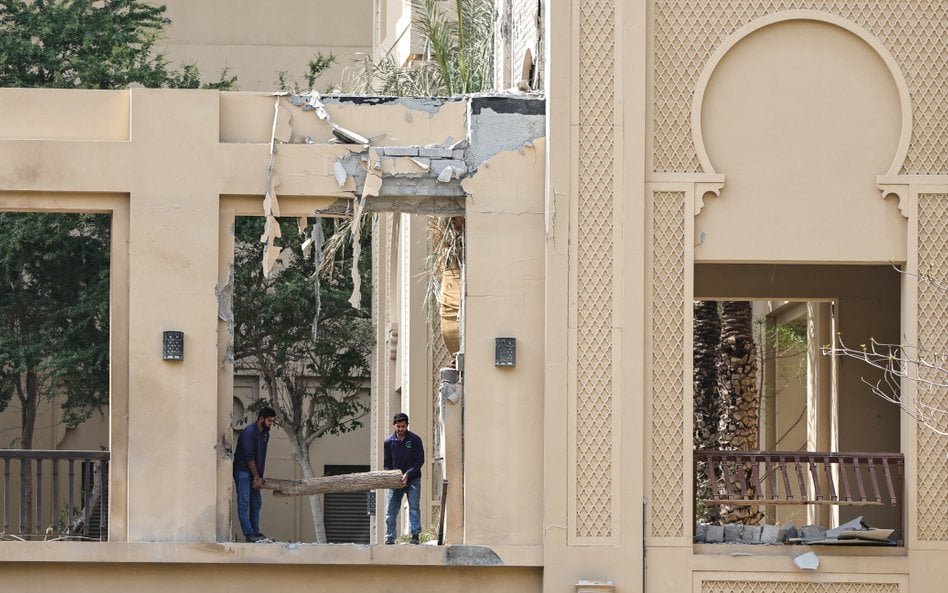 Robotnicy usuwają gruz ze zniszczeń spowodowanych przez irański dron w hotelu Fairmont w Dubaju