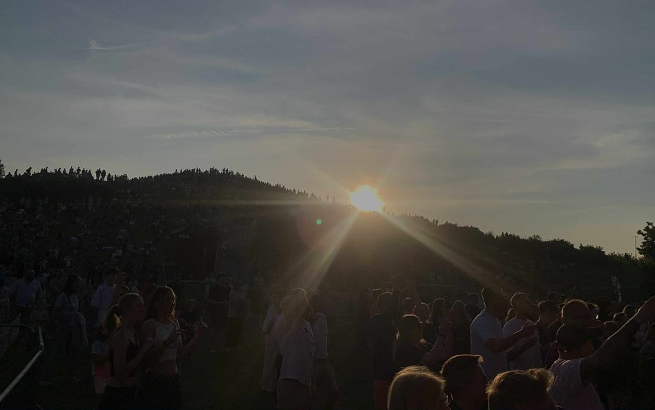 Magiczny moment zachodu słońca nad Kopą Cwila. Promienie słońca przebijają się przez horyzont, oświe