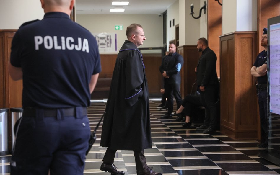 Pełnomocnik prezydenta Karola Nawrockiego mec. Adrian Salus (C) w Sądzie Okręgowym w Warszawie przed