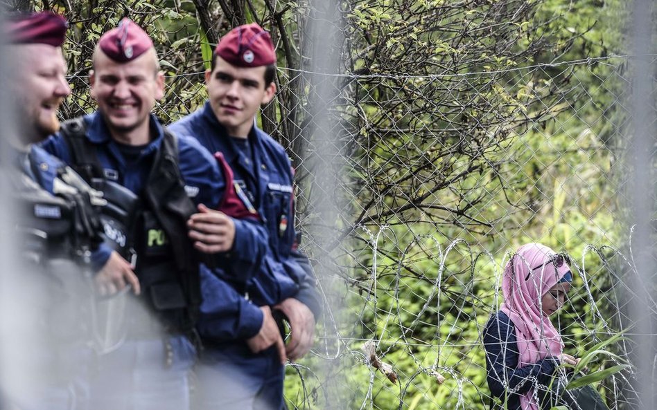 Węgierska straż graniczna i imigrantka przy węgierskiej granicy z Serbią w pobliżu miasta Horgoš