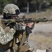 Ukraiński żołnierz strzela z karabinu automatycznego podczas ćwiczeń w obwodzie kijowskim