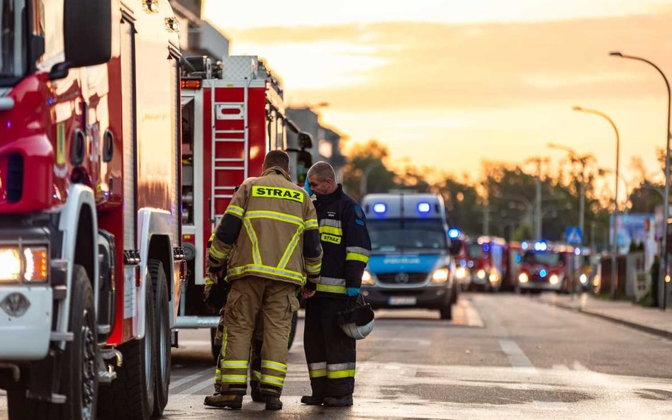 Policjanci przed spalonym budynkiem w Ząbkach