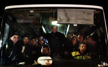 Imigranci na włoskiej wyspie Lampedusa jadą autobusem do tymczasowych ośrodków zakwaterowania