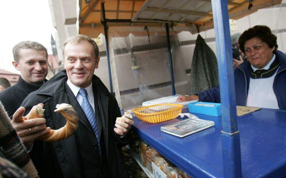 Donald Tusk kupuje tradycyjnego precla podczas swojej wizyty w Krakowie w październiku 2007 r.