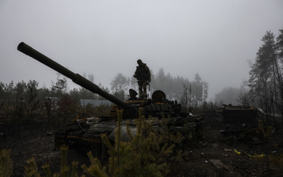 Ukraiński żołnierz przy zniszczonym rosyjskim czołgu
