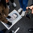 Demonstranci stoją na zdjęciu Baszara Asada podczas protestu przed syryjskim konsulatem w Stambule. 