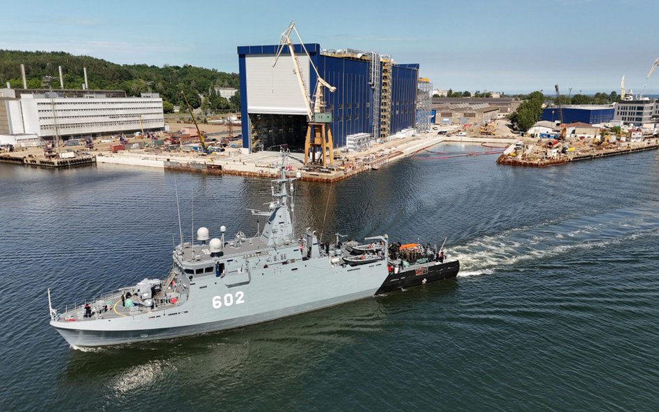 Niszczyciel min ORP Albatros (602) na tle hali w której powstanie ORP Wicher (pierwsza polska fregat
