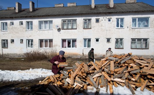 Emeryci zbierają drewno na opał w pobliżu swojego domu w małym miasteczku Moszenskoj w obwodzie nowg