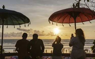 Turyści obserwują zachód słońca na Bali.