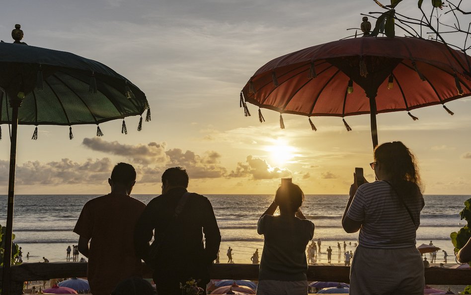 Turyści obserwują zachód słońca na Bali.