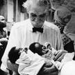 Albert Schweitzer (1875–1965) trzyma dwoje noworodków urodzonych w szpitalu w Lambarene we Francuski