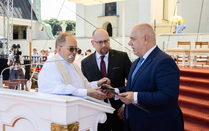 Minister aktywów państwowych Jacek Sasin i prezes Enei Paweł Majewski wręczają o. Tadeuszowi Rydzyko